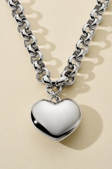 A silver heart shaped pendant necklace on a bold chain.