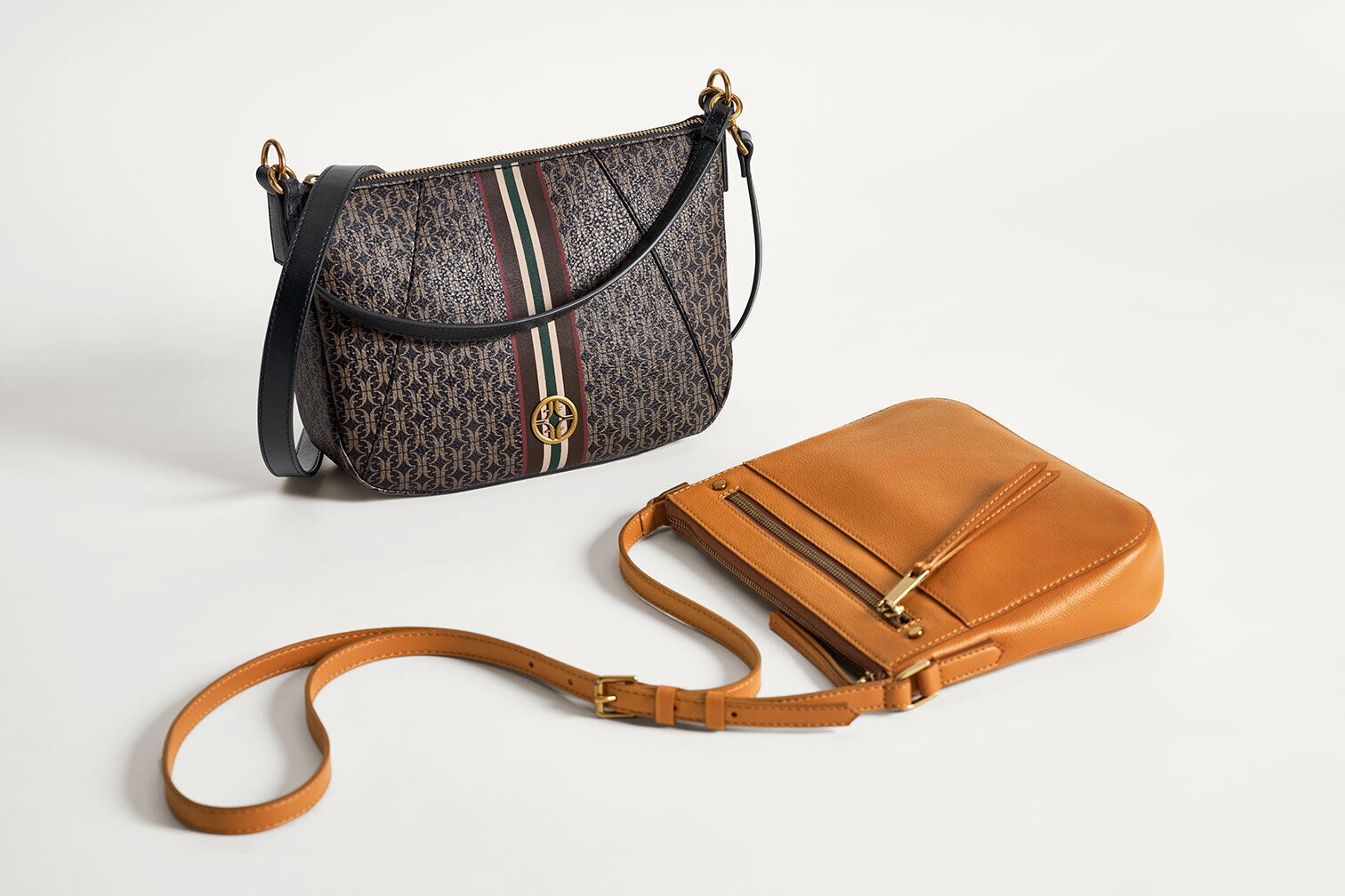 Two Fossil women's leather handbags in brown and black colorways.