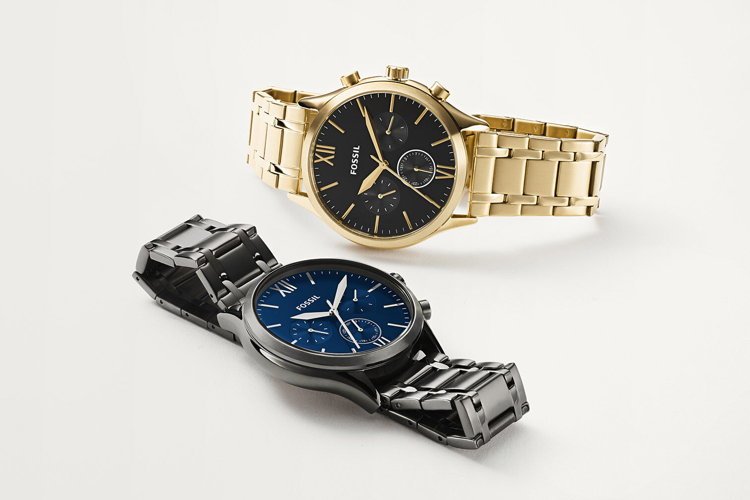 Two Fossil men's watches in silver and gold tone stainless steel.