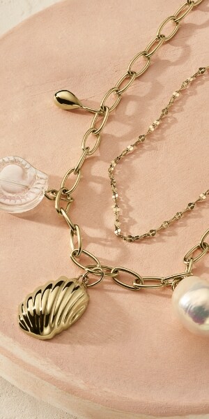 Bijoux dorés avec des perles de culture d’eau douce baroques et des motifs de coquillages.