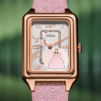Une montre rose étincelante avec un boîtier rectangulaire et des détails inspirés par Glinda la bonne sorcière.