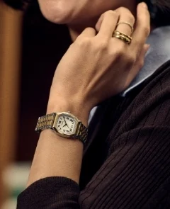 A lifestyle image of a woman wearing the Harlow watch with a green leather strap.