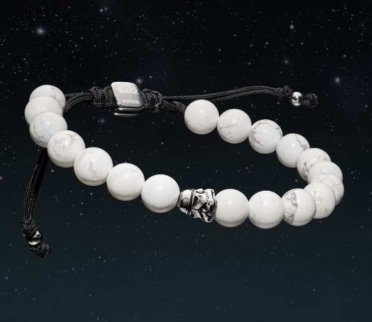 Images côte à côte d’un bracelet de perles blanches, dont une en forme de casque de stormtrooper, et d’un bracelet de perles en grès bleu, dont une en forme de casque de Dark Vador.