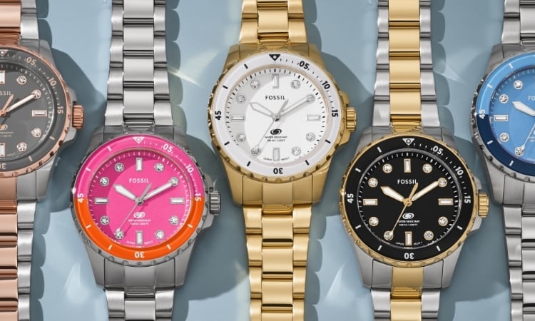 Cinq montres Fossil Blue Dive, dont une avec un bracelet bicolore et un cadran gris ; une avec un bracelet argenté et un cadran rose et orange ; une avec un bracelet doré et un cadran blanc ; une avec un bracelet bicolore et un cadran noir ; une avec un bracelet argenté et un cadran bleu marine et bleu clair.