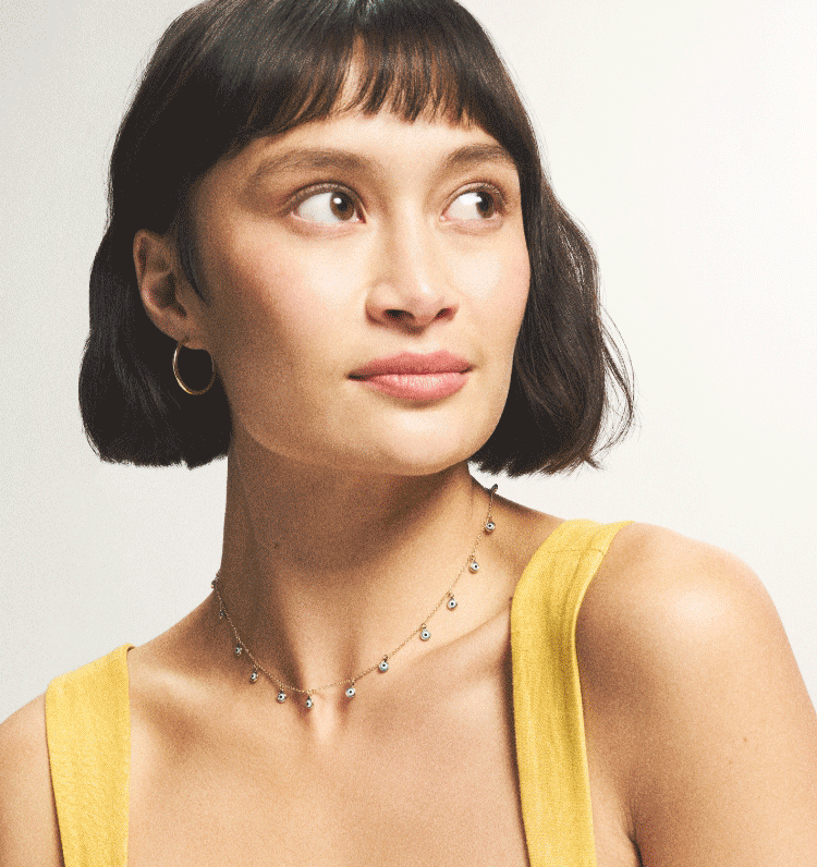 A women wearing a eveil eye collection necklace