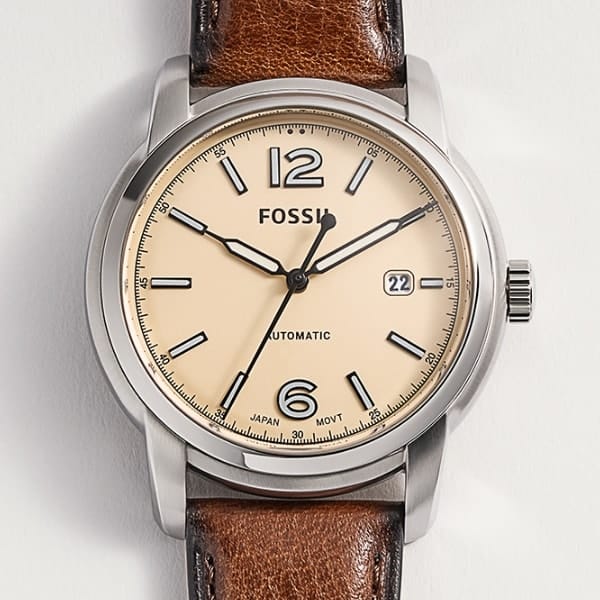 Un orologio Fossil Heritage da uomo con cinturino in pelle marrone e quadrante smaltato.