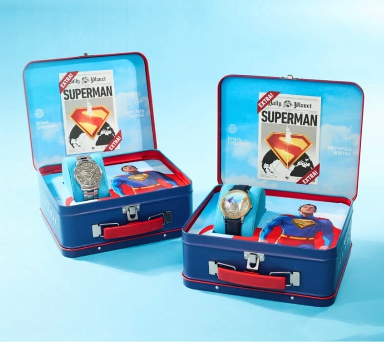 Lunchbox-style collectible packaging displaying the limited-edition watches and miniature newspaper insert.
