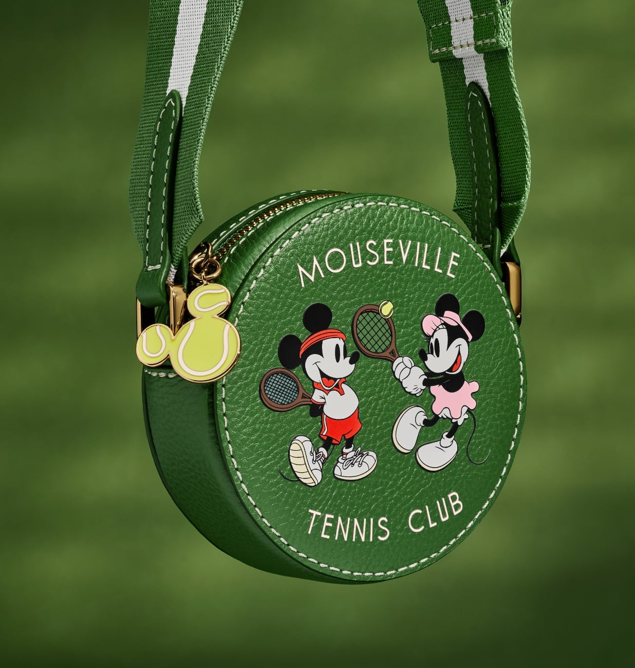 スペシャルエディションのミニクロスボディハンドバッグのクローズアップ画像。丸みのあるグリーンレザーのバッグには、ミッキーとミニーがテニスをしているスクリーンプリントのグラフィックがあしらわれています。