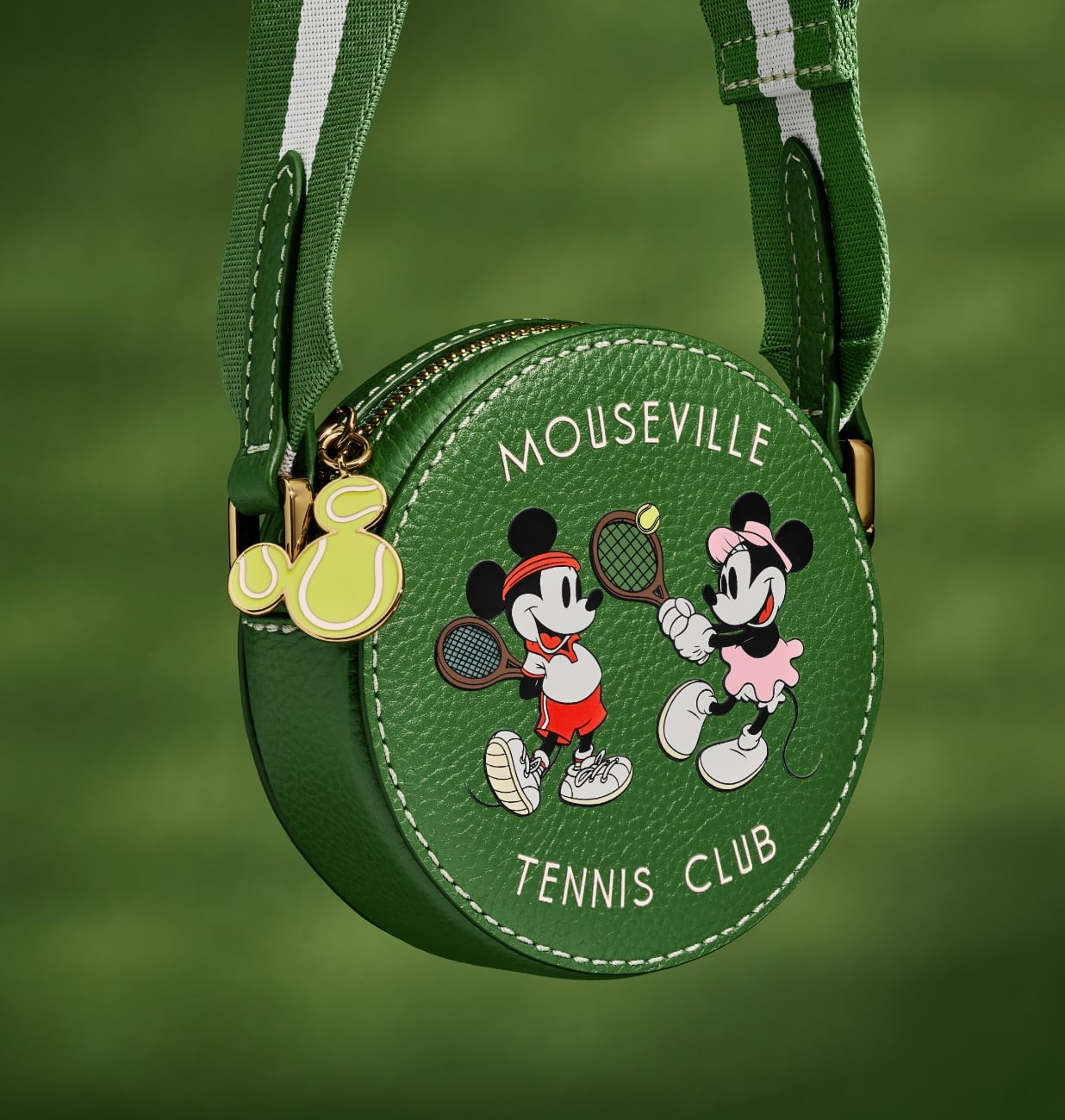 Imagen en primer plano de nuestro minibolso bandolera en edición especial, con una forma redonda en piel verde y un gráfico serigrafiado de Mickey y Minnie jugando al tenis. 
