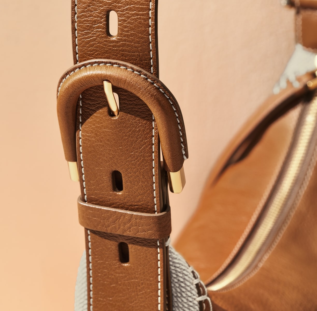 A GIF of the Harwell leather and cotton bag with a closeup of its leather-wrapped buckle detail.