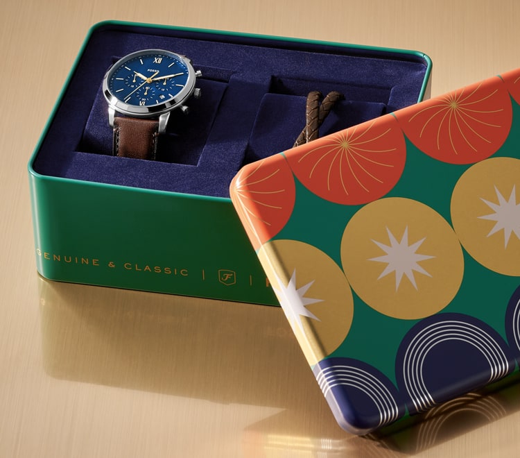 Gif of a brightly colored Fossil gift set tin opening to reveal a men's brown leather watch and brown leather bracelet.