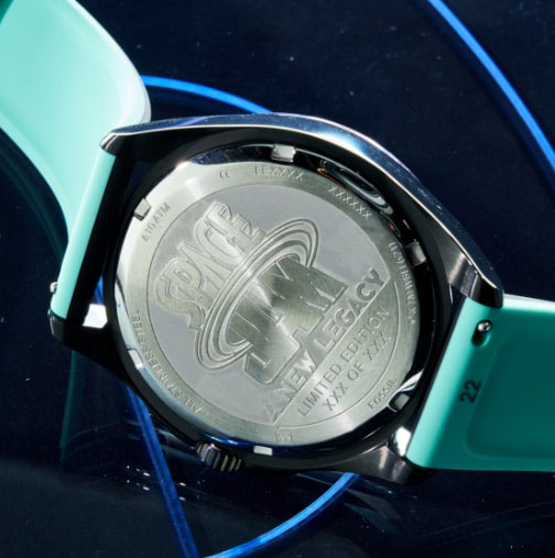 Image of watch tin and watch showing etched caseback.