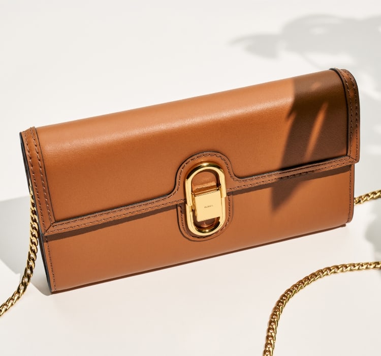 Four pairs of stud earrings sit on a table: a pair of blue heart crystals with yellow enamel edging, a pair of pink heart crystals with pink enamel edging, a pair of snake studs with green and yellow enamel, a pair of pink enamel mushroom studs with gold-tone stainless steel and crystal embellishments.