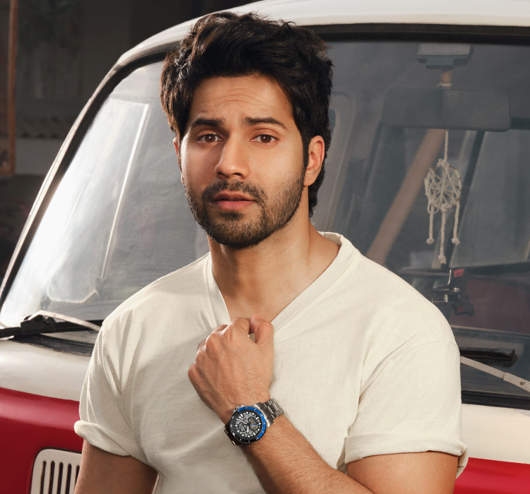Man wearing a watch and standing in front of a vintage bus.