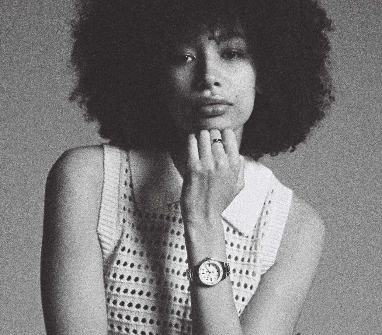 A black-and-white image of a woman wearing the Fossil Blue Dive watch.