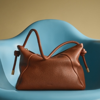 The brown leather Willa bag sitting on a blue chair.