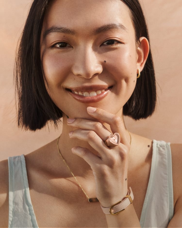 Donna sorridente che indossa un orologio ad anello color oro rosa.