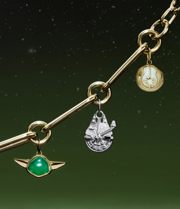 Una pulsera en tono dorado con charms en forma de Yoda, Halcón Milenario, C-3PO, R2-D2 y una espada láser.