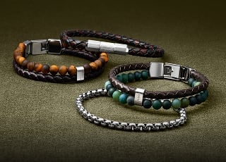 An artful arrangement of men's bracelets, including beaded, textured leather and silver-tone chains.