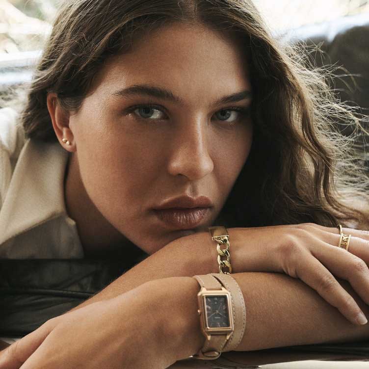 A woman wearing the square-shaped Raquel watch with double-wrap leather strap in blush.