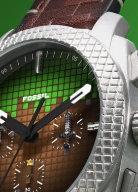 Cadran de montre vert et brun et lunette argentée avec une texture quadrillée, conçus pour imiter un bloc d’herbe de Minecraft.