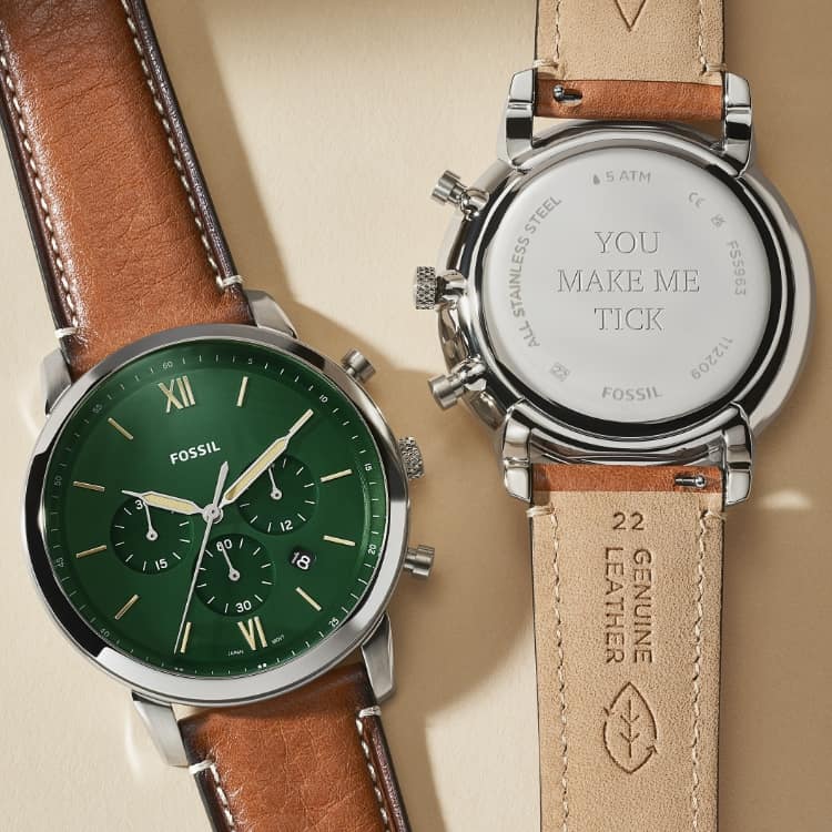Deux montres en cuir brun. L’une montrant le dos gravé de « You Make Me Tick ».