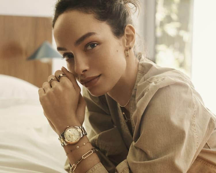 Woman wearing a two-tone Fossil Heritage watch with the Fossil Heritage D-Link jewellery collection.