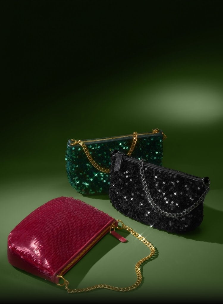 Trois pochettes à paillettes avec un bracelet chaîne en rouge, vert émeraude et noir.