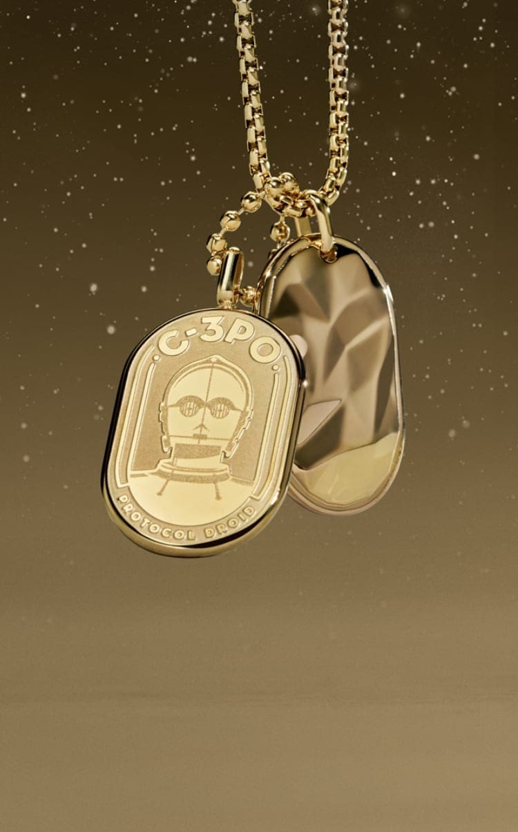Un collar en tono dorado con un grabado de C-3PO en una chapa de identificación