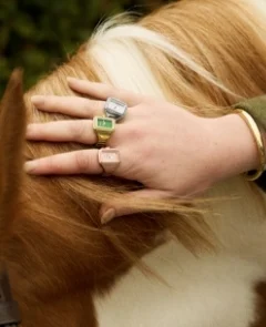A woman wearing watch rings stacked on multiple fingers of both hands.