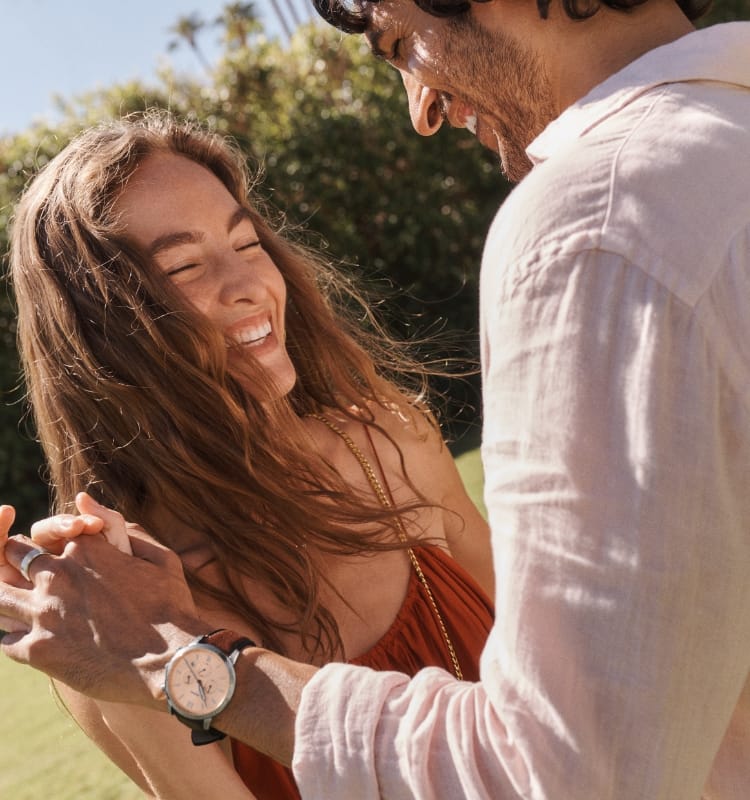 A man and a woman holding hands and laughing; two women embracing and smiling.