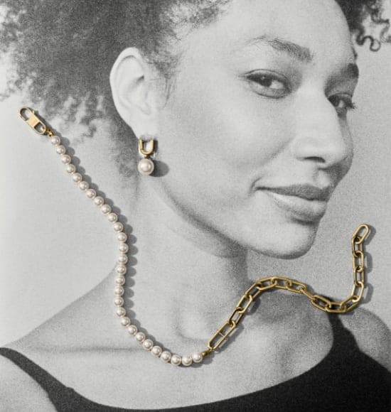 A black-and-white photo of a woman with a gold-tone and imitation glass pearl necklace and imitation glass pearl earrings draped over the image.