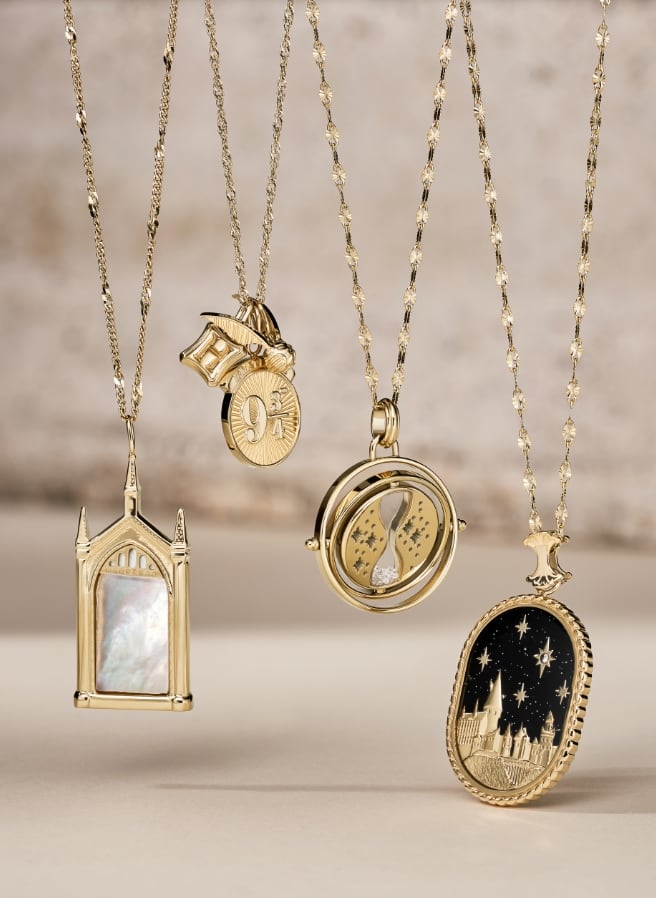 Four gold-tone Harry Potter x Fossil necklaces.