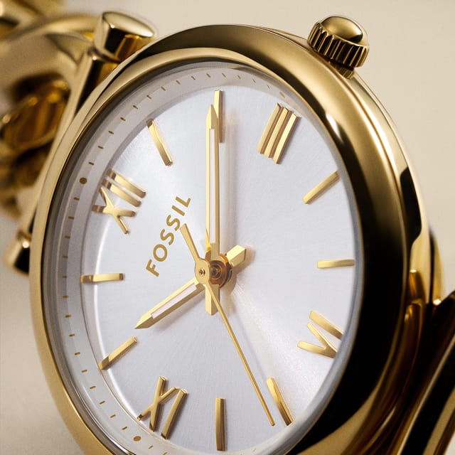 A round-faced, gold-tone watch with a silver sunray dial.