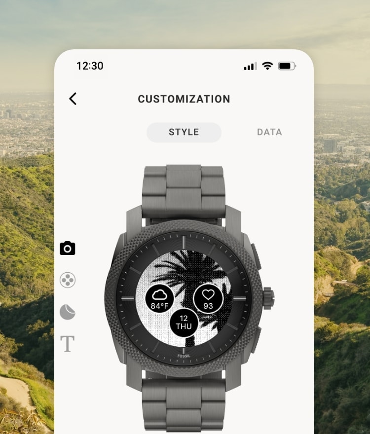 A scenic background behind a simulated smartphone screen showcasing the Customisation functionality of the new Fossil Smartwatches app