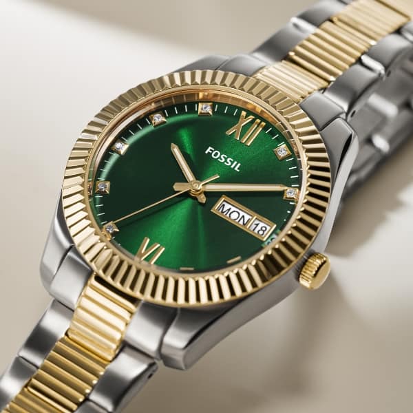 Une montre Fossil bicolore avec un cadran vert.