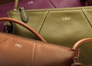 The Willa bag, a relaxed silhouette crafted of pebbled leather, shown in rich shades of brown, olive and berry with custom embossing.