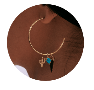 A hoop earring with three charms on it.
