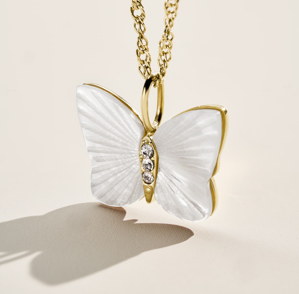 A GIF of the mother-of-pearl Butterfly Collection, featuring a closeup of the necklace with crystals and a group shot of the earrings, necklace and ring.