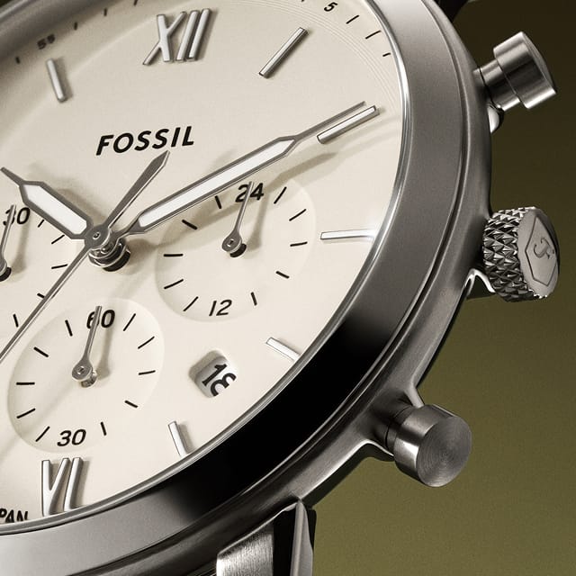 A round-faced watch featuring a chronograph movement and brown leather strap.