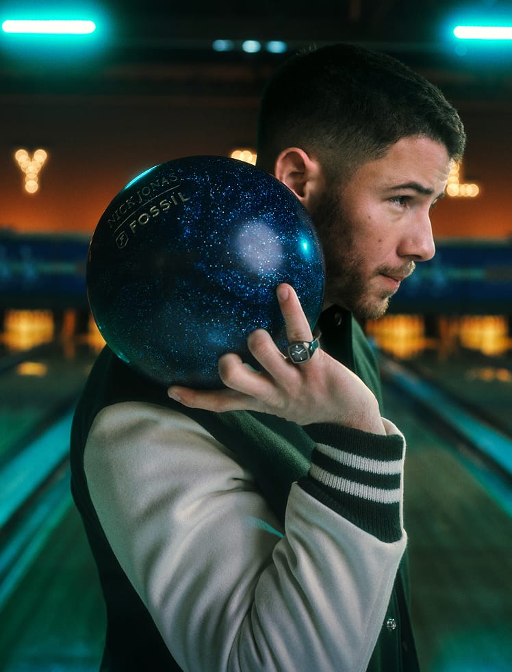 An image of Nick holding a bowling ball wearing the Machine Luxe watch ring on his pinkie finger.