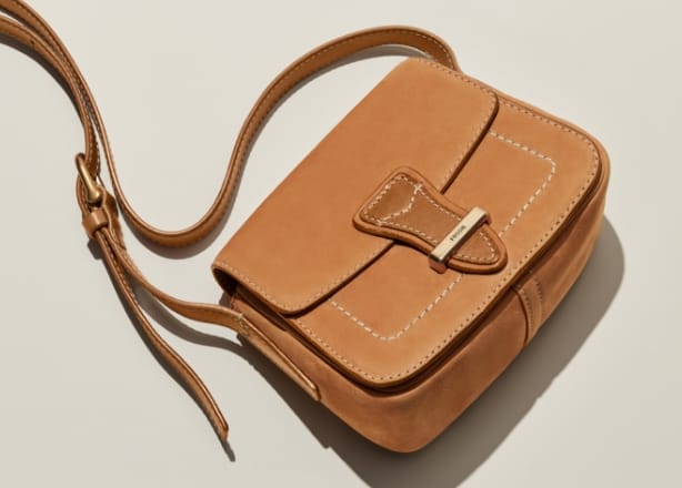 A GIF of a brown suede Tremont bag, featuring a closeup of the tri-colour hand-tacking and raw edges.