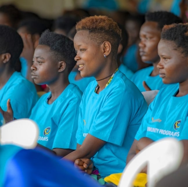 Un groupe d’enfants assis ensemble portant des t-shirts assortis.