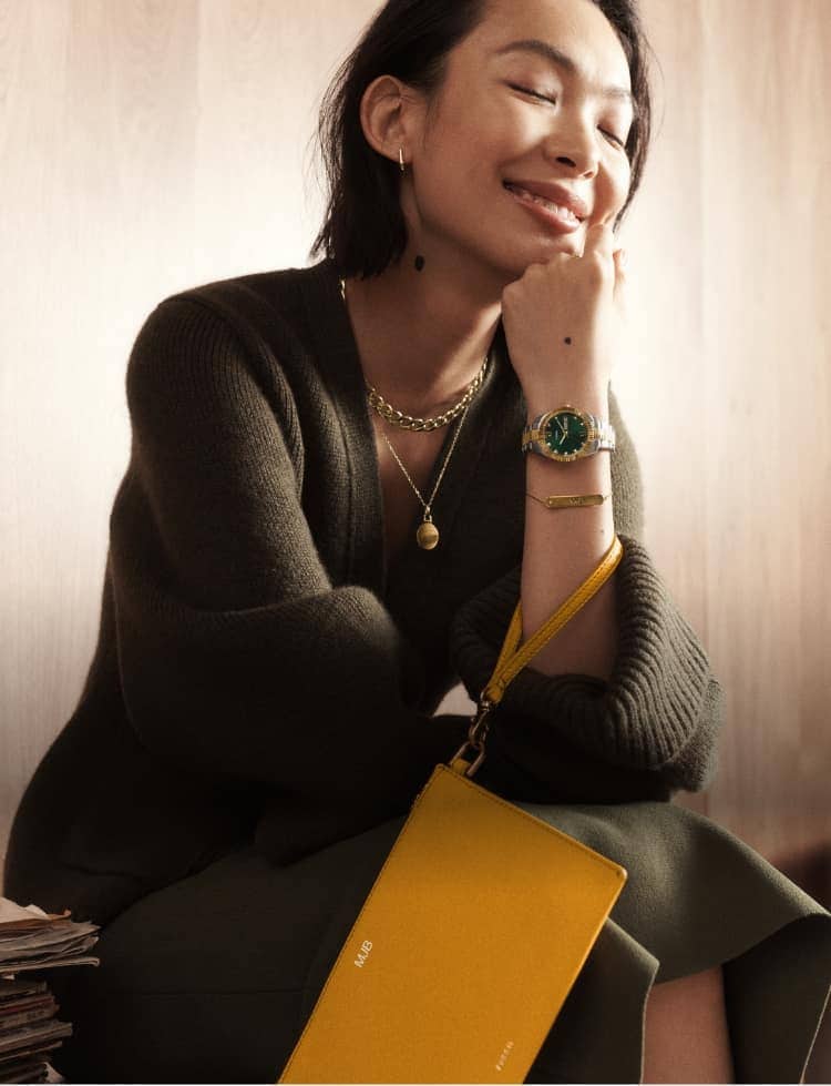 A woman wearing Fossil gold-tone jewellery and a Fossil watch. A star graphic.