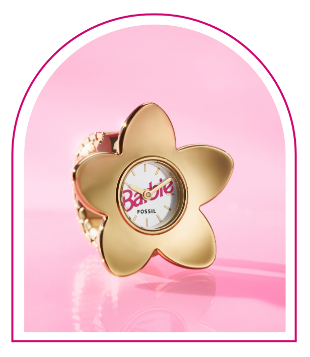 A pink background with a Barbie™ Mansion-inspired window. Inside the window sits our limited edition Barbie™ x Fossil watch ring, featuring a gold-tone five-petal flower design, white dial with pink Barbie logo and flexible band to fit any finger.