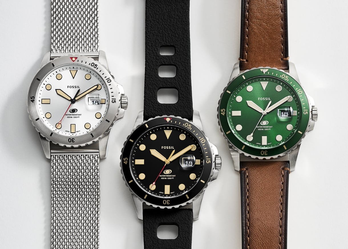 Trois montres Fossil Blue pour hommes avec bracelet en mailles d’acier inoxydable, un bracelet en silicone noir et un bracelet en cuir brun.
