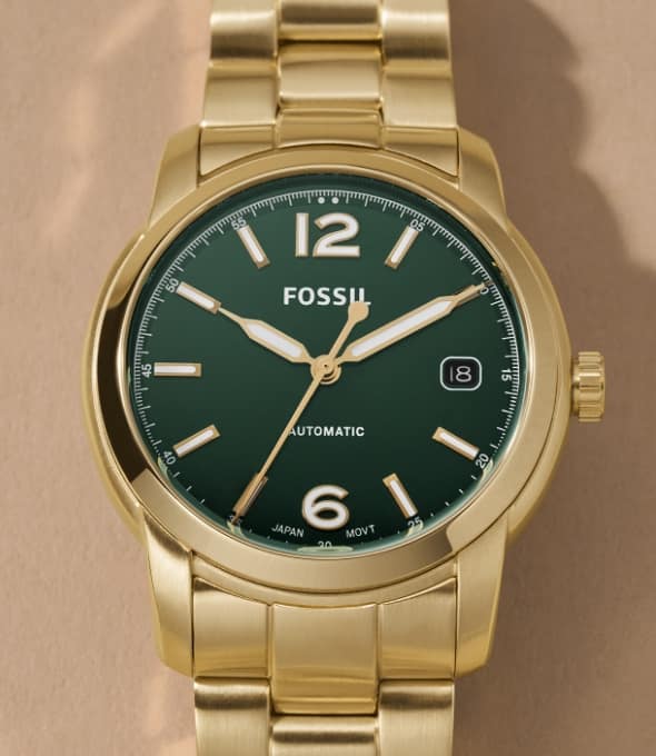 A gold-tone Fossil Heritage watch with a green dial. 