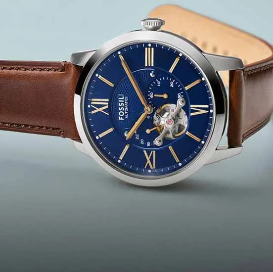 The Fossil Neutra automatic watch, showcasing a deep blue skeletonised dial and brown leather strap.