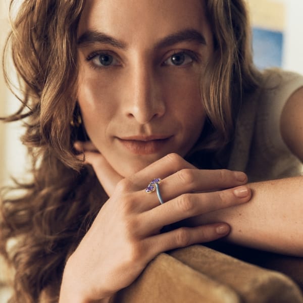 A woman wearing the colored enamel ring with crystals. 