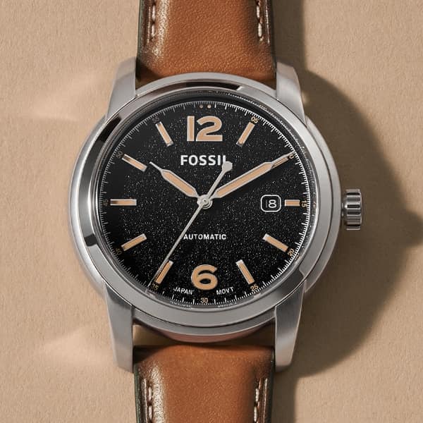 A brown leather Fossil Heritage watch with black dial.